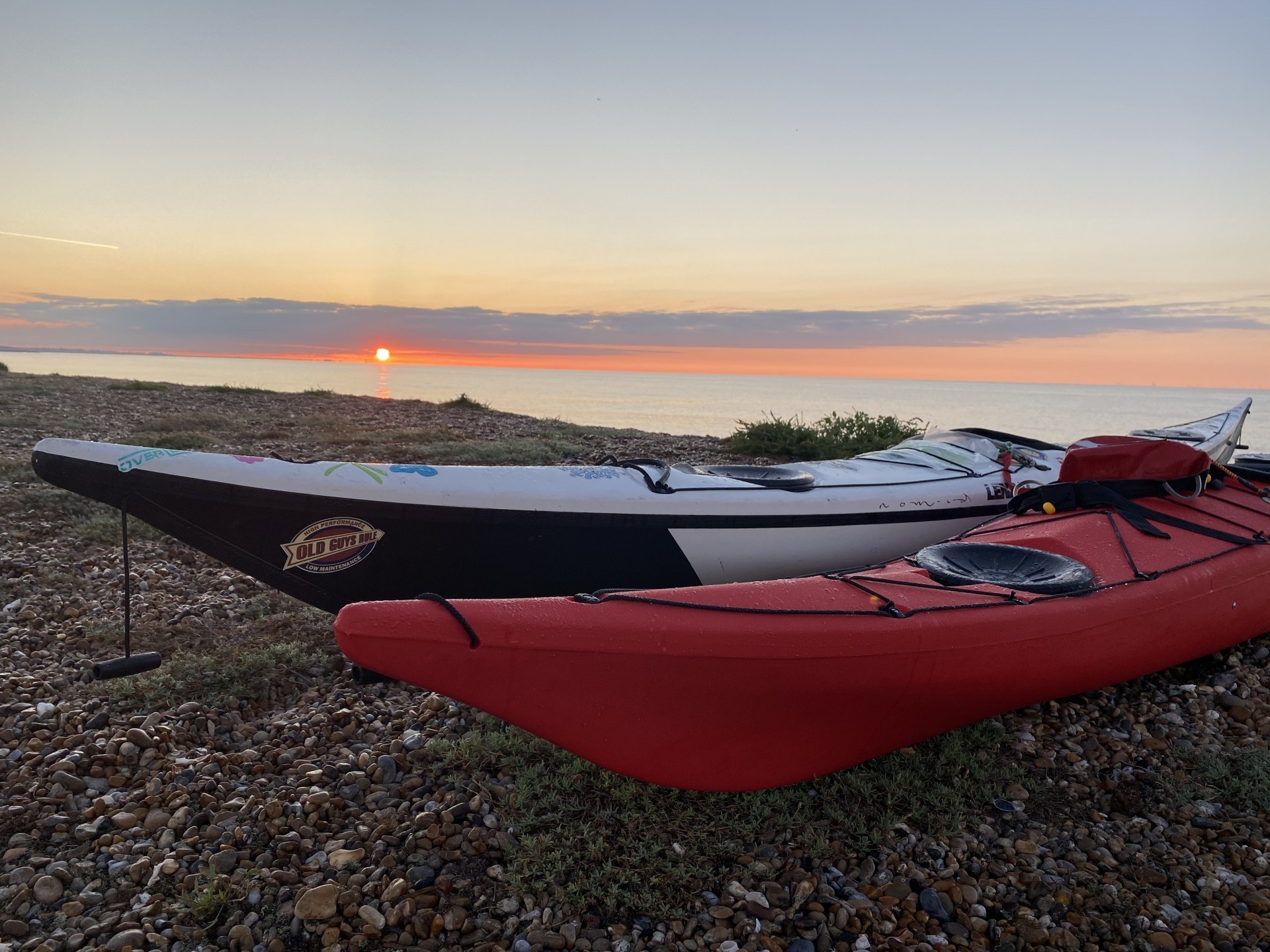 Sea kayaks at sunset in Suffolk with NOMAD Sea Kayaking.